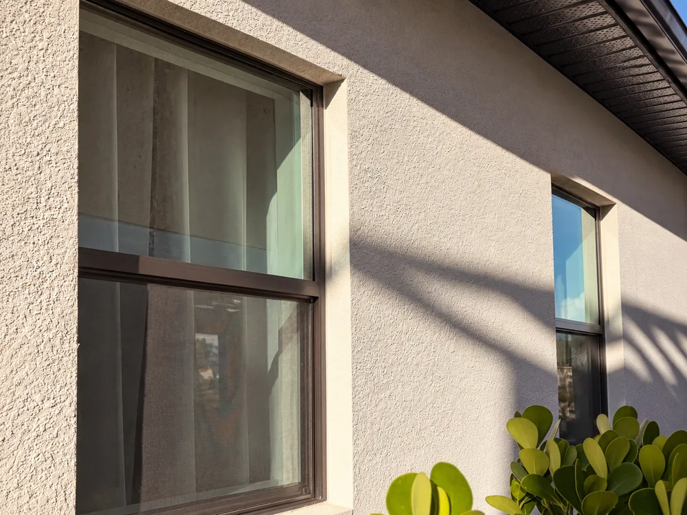 Exterior windows on a stucco home in warm natural light